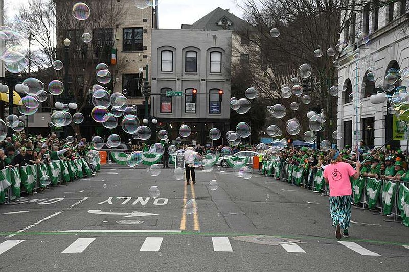 Big Poppa Bubbles blows bubbles over the crowd before the start of the First Ever 21st Annual World's Shortest St. Patrick's Day Parade Sunday on Bridge Street. (The Sentinel-Record/Lance Brownfield)