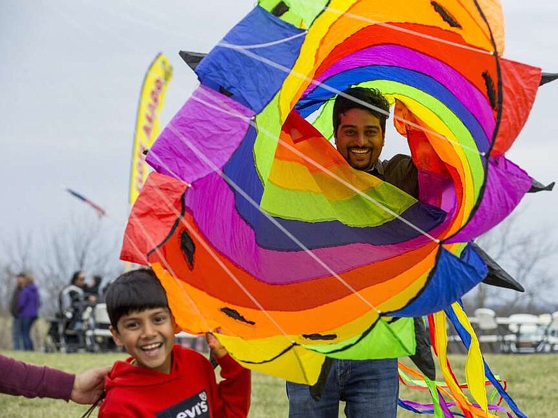 NWA Democrat-Gazette/BEN GOFF @NWABENGOFF
Harish Nayak and son Surya Nayak, 7, of Bentonville goof around with a large wind sock Saturday, March 23, 2019, during the 29th annual Eureka Springs Kite Festival hosted by Turpentine Creek Wildlife Refuge in Eureka Springs. The free family event included kite making and kites for sale from Keleidokites in Eureka Springs and a variety of food trucks and entertainment. Strong wind kept dozens of kites flying high at any given time.