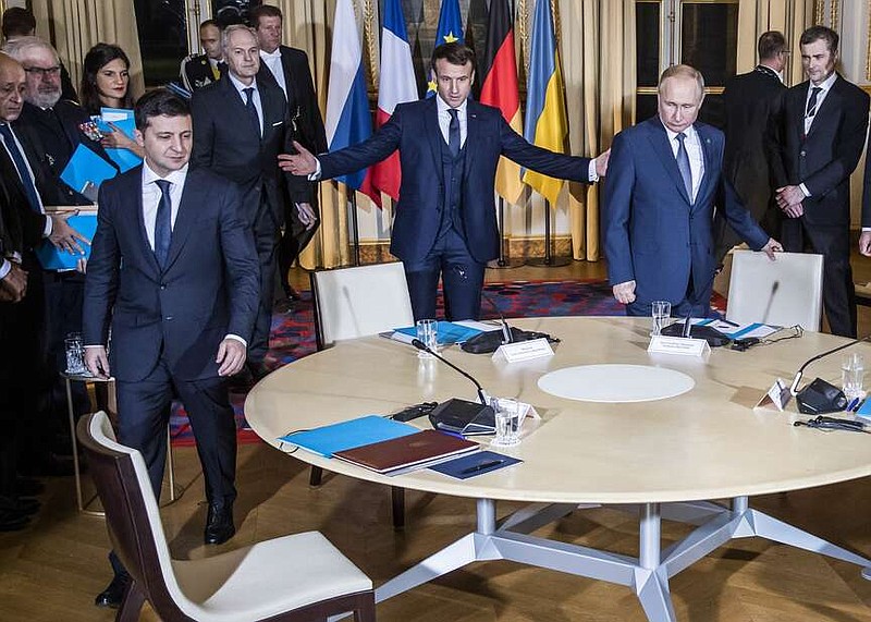 FILE - Russian President Vladimir Putin, right, French President Emmanuel Macron, center, and Ukrainian President Volodymyr Zelenskyy take part at a meeting in the Elysee Palace in Paris, France, on Monday, Dec. 9, 2019. Russia viewed Zelenskyy's victory in Ukraine's 2019 presidential election as a chance to revive the anemic Minsk peace deal for eastern Ukraine, but Zelenskyy stood his ground, leaving the agreement stalled and Putin increasingly exasperated. (Christophe Petit Tesson/Pool via AP, File)