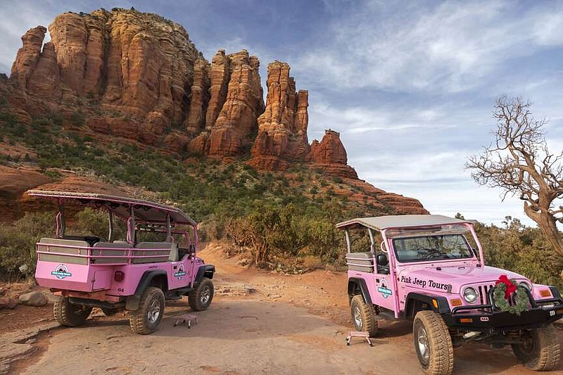 Two Pink Jeep off-road terrain vehicles with tourists touring Broken Arrow Slick Rock near Sedona, Arizona. (Zeljkokcanmore/Dreamstime/TNS)
