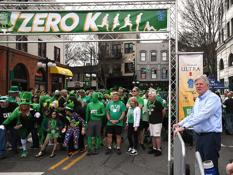 Hot Springs Mayor Pat McCabe stands behind the barricades as participants in the Third Ever Zero-K World's Shortest St. Patrick's footrace prepare to start Saturday. (The Sentinel-Record/Lance Brownfield)