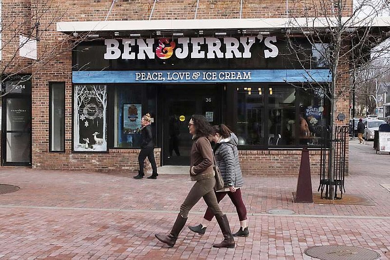 FILE - Pedestrians walk on Church St., past the Ben & Jerry's shop, in Burlington, Vt., Wednesday, March 11, 2020. Unilever, the company that makes Ben & Jerry's ice cream, Dove soaps and Vaseline, said Tuesday, March 19, 2024, that it is cutting 7,500 jobs and spinning off its ice cream business to reduce costs and boost profits. (AP Photo/Charles Krupa, File)