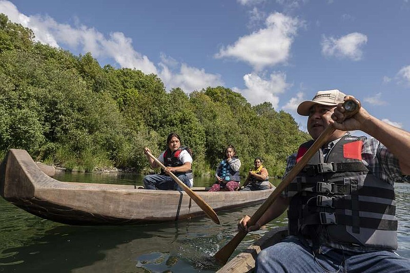 FILE - Yurok tribal members lead a redwood canoe tour on the lower Klamath River on Tuesday, June 8, 2021, in Klamath, Calif. As the salmon of the Klamath have dwindled the Yurok tribe has turned to alternative revenue like eco tourism and canoe tours in an effort to support their people. The Yurok Tribe, which lost 90 percent of its ancestral land during the Gold Rush in the mid-19th century, is getting back a slice of its territory under an agreement signed Tuesday, March 19, 2024, with California and the National Park Service. (AP Photo/Nathan Howard, File)