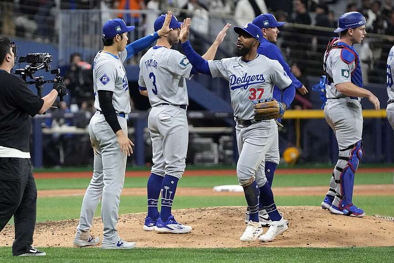 Los Angeles Dodgers designated hitter Shohei Ohtani, second from left, congratulates Teoscar Hernandez after the Dodgers defeated the San Diego Padres 5-2 in an opening day game at the Gocheok Sky Dome in Seoul, South Korea Wednesday. (AP Photo/Lee Jin-man)
