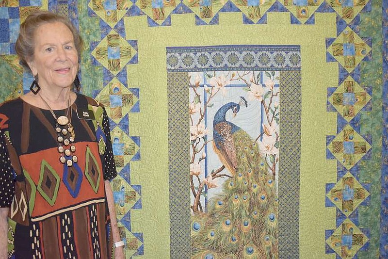 Rachel Dickerson/The Weekly Vista 
Resident Betty O'Neill is pictured with one of her quilts at a quilt show at Concordia Retirement Community on March 20. The quilt is double-sided and features peacocks. It is Japanese-inspired and made from Indonesian fabric.
