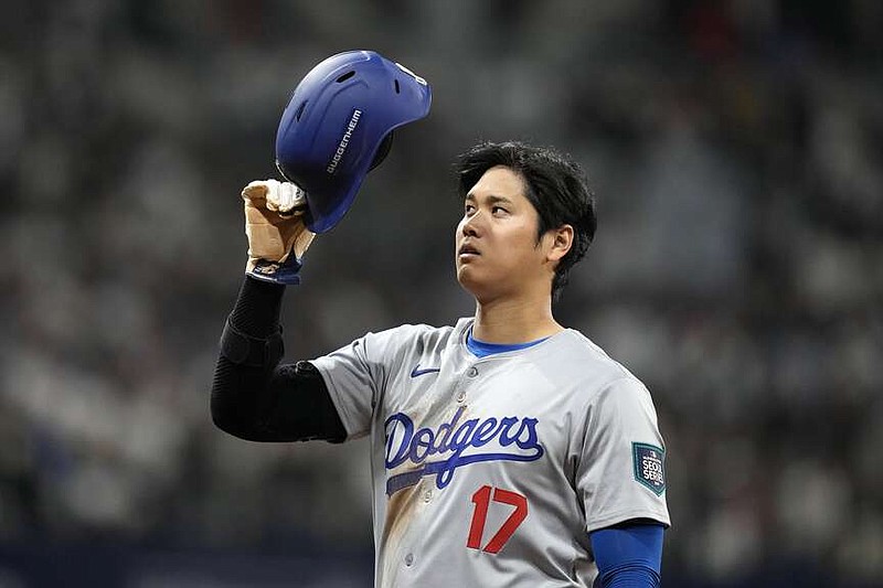 Los Angeles Dodgers designated hitter Shohei Ohtani takes his helmet off after hitting an RBI single during the eighth inning of an opening day baseball game against the San Diego Padres at the Gocheok Sky Dome in Seoul, South Korea Wednesday, March 20, 2024, in Seoul, South Korea. (AP Photo/Lee Jin-man)