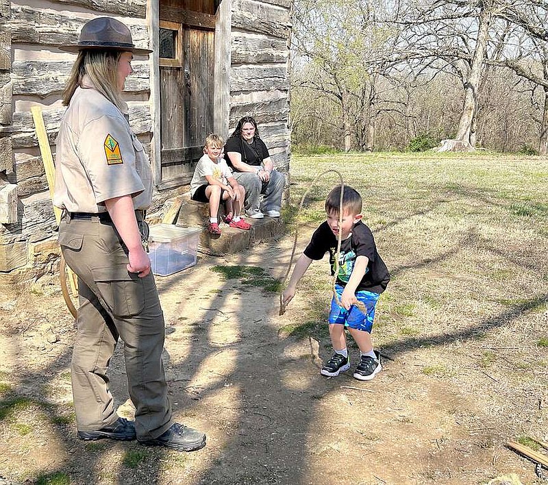 Lynn Kutter/Enterprise-Leader
Mattison Griffin, interpreter with Prairie Grove Battlefield State Park, teaches children some pioneer games Wednesday, March 20, as one of many activities scheduled at the park during Spring Break. Here, the children jumped rope using rope that would have been used during Civil War times, not a nylon one used by children today. Griffin also demonstrated how to use wooden stilts, to roll large wood hoops on the ground and how to use two sticks to throw and catch a hoop, called "Game of Graces."