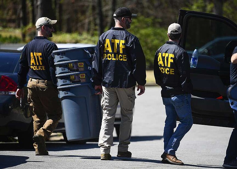 ATF agents carry plastic trash cans toward a house on Durance Court in Little Rock as the Arkansas State Police (ASP) Criminal Investigation Division investigates an officer-involved shooting that occurred Tuesday around 6 a.m. while the Bureau of Alcohol, Tobacco, Firearms and Explosives was serving a federal search warrant. Bryan Malinowski, 53, was injured with gunshot wounds and treated on scene by paramedics before being transported to a local hospital. He later died from his injuries. (Arkansas Democrat-Gazette/Stephen Swofford)