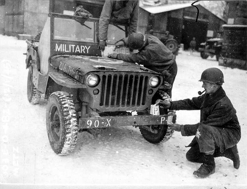 This photo provided by the Ghost Army Legacy Project shows a  Jeep getting new bumper markings for special effects. For decades, their mission during World War II was a secret. With inflatable tanks, trucks and planes, combined with sound effects, radio trickery, costume uniforms and acting, the American military units that became known as the Ghost Army helped outwit the enemy. Now, they are being awarded the Congressional Gold Medal on Thursday, March 21, 2024.  (National Archives/Ghost Army Legacy Project via AP)