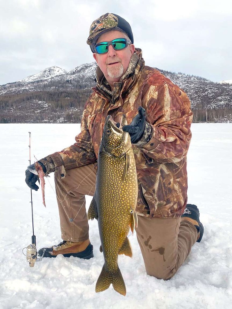 Mark "Hog Ears" Hughes with a lake trout he caught in February while ice fishing near Anchorage, Alaska.
(Courtesy photo)