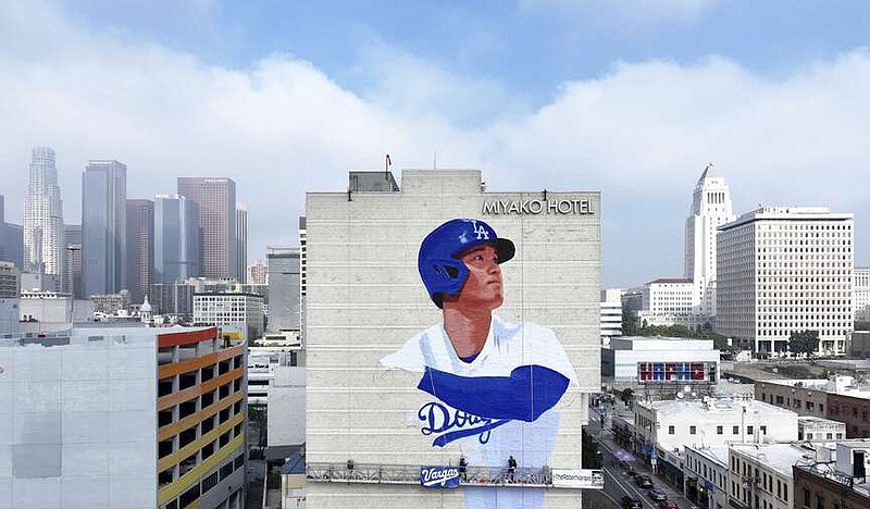 Muralist Robert Vargas, center, works on a new Los Angeles Dodgers baseball player Shohei Ohtani mural titled "L.A. Rising," Wednesday, on the Miyako Hotel in the Little Tokyo area of Los Angeles. (Dean Musgrove/The Orange County Register via AP)