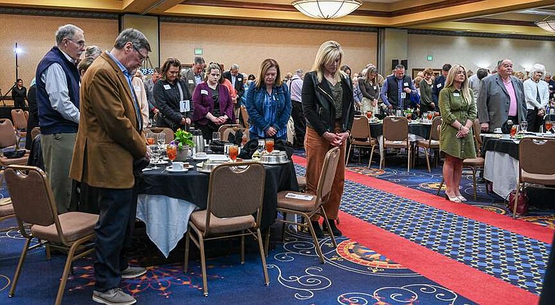 Julie Smith/News Tribune
Attendees to Thursday's Vitae luncheon stand and bow their head in prayer before the start of formal actiivities at the annual fundraising banquet and Capitol Plaza Hotel.