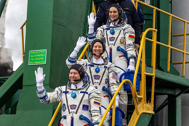In this photo released by Roscosmos space corporation, NASA astronaut Tracy Dyson, centre, Oleg Novitsky of Roscosmos, bottom, and Marina Vasilevskaya of Belarus wave as they board to the space ship at the Russian leased Baikonur cosmodrome, Kazakhstan, Thursday, March 21, 2024. Russia's Roscosmos space agency has aborted the launch of three astronauts to the International Space Station about 20 seconds before they were scheduled to lift off. Officials say the  crew is safe. The Russian Soyuz rocket was to carry NASA astronaut Tracy Dyson, Oleg Novitsky of Roscosmos and Marina Vasilevskaya of Belarus from the Russia-leased Baikonur launch facility in Kazakhstan. (Roscosmos space corporation via AP)