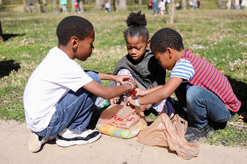 News Tribune file
From left, Pate siblings Liam, 8, Zariyah, 3, and Adonis, 6, remove candy from eggs after last year's egg hunt at Memorial Park.