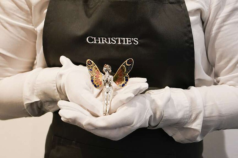 A member of staff holds a fairy pendant, as part of The Pattie Boyd Collection at Christie's, in London, Thursday, March 14, 2024. The pendanr is estimated to sell £2,000-3,000. (AP Photo/Alberto Pezzali)