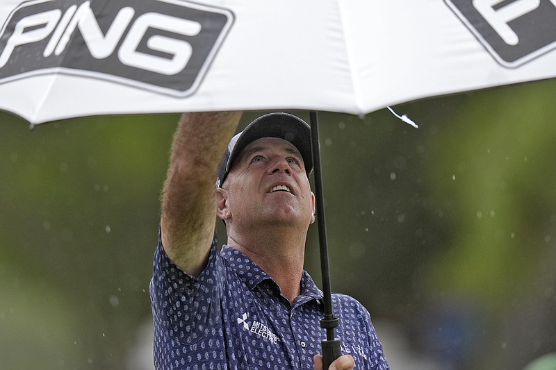 Stewart Cink puts his his umbrella as the rain begins to fall on the eighth hole during the second round of the Valspar Championship golf tournament Friday, March 22, 2024, at Innisbrook in Palm Harbor, Fla. (AP Photo/Chris O'Meara)