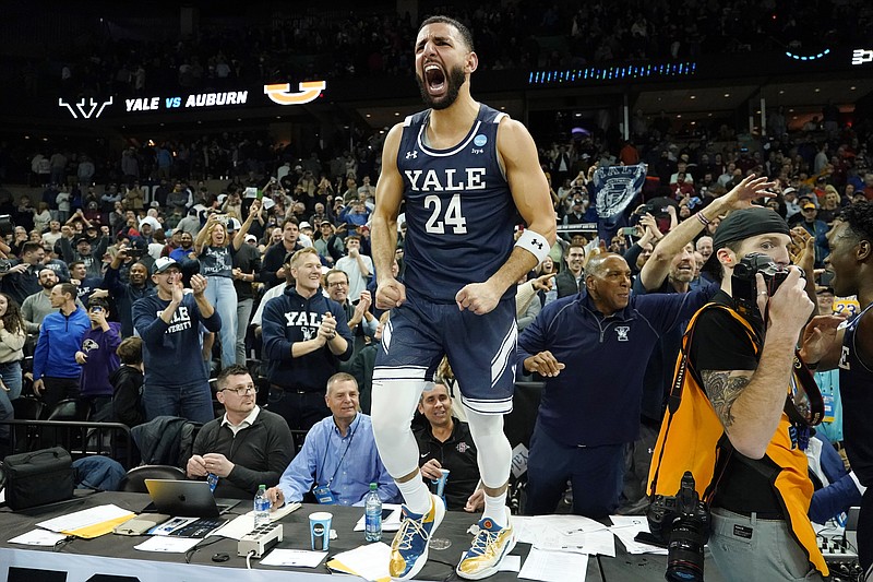 Yale guard Yassine Gharram (24) stands on a table after celebrating with fans after Yale upset Auburn in a first-round college basketball game in the NCAA Tournament in Spokane, Wash., Friday, March 22, 2024. (AP Photo/Ted S. Warren)