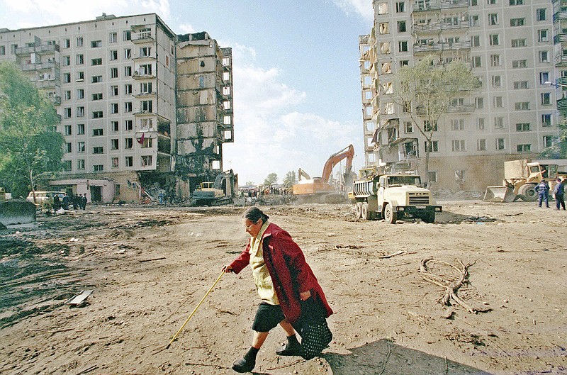FILE - A local resident passes the apartment building destroyed the day before, by an explosion in Moscow, Friday, Sept. 10, 1999. The attack on a Moscow concert hall in which armed men opened fire and set the building ablaze, killing over 130 people, was the latest in a long series of bombings and sieges that have unsettled and outraged Russians during Vladimir Putin&#x2019;s nearly quarter-century as either prime minister or president. (AP Photo/Misha Japaridze, File)