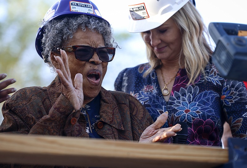 Opal Lee, left, applauds during a ceremony before aising the first wall to her new home on her family's former lot in Fort Worth, Texas on Thursday, March 21, 2024. Lee, one of the driving forces behind Juneteenth becoming a national holiday, attended a ceremony to watch as the walls are raised on new home.  In 1939, a racist mob drove her family out of their home. (Amanda McCoy /Star-Telegram via AP)