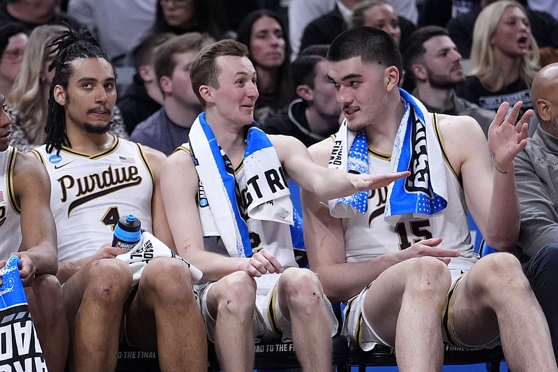 Purdue forward Trey Kaufman-Renn, from left, guard Fletcher Loyer and center Zach Edey watch from the bench in the second half of a first-round college basketball game against Grambling State in the NCAA Tournament, Friday, March 22, 2024, in Indianapolis. Purdue won 78-50. (AP Photo/Michael Conroy)