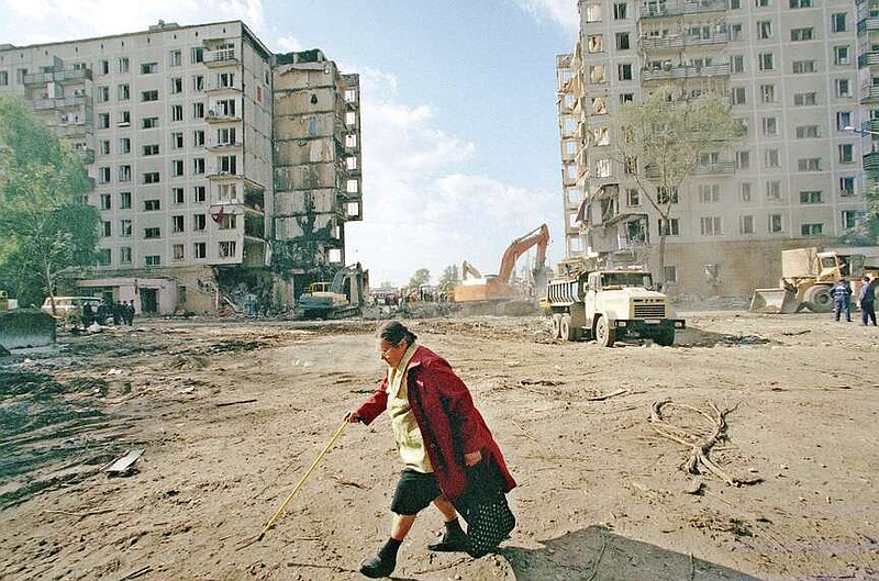 FILE - A local resident passes the apartment building destroyed the day before, by an explosion in Moscow, Friday, Sept. 10, 1999. The attack on a Moscow concert hall in which armed men opened fire and set the building ablaze, killing over 130 people, was the latest in a long series of bombings and sieges that have unsettled and outraged Russians during Vladimir Putin's nearly quarter-century as either prime minister or president. (AP Photo/Misha Japaridze, File)
