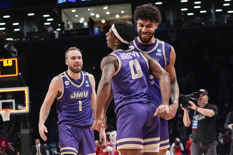 James Madison guard Xavier Brown (0), guard Noah Freidel (1) and forward Julien Wooden celebrate after James Madison defeated Wisconsin during a first-round college basketball game in the men's NCAA Tournament, Saturday, March 23, 2024, in New York. (AP Photo/Mary Altaffer)