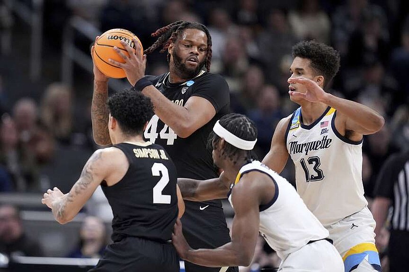 Colorado's Eddie Lampkin Jr. (44) holds the ball as Marquette's Oso Ighodaro (13) defends during the first half of Sunday's game in Indianapolis. (AP Photo/Michael Conroy)