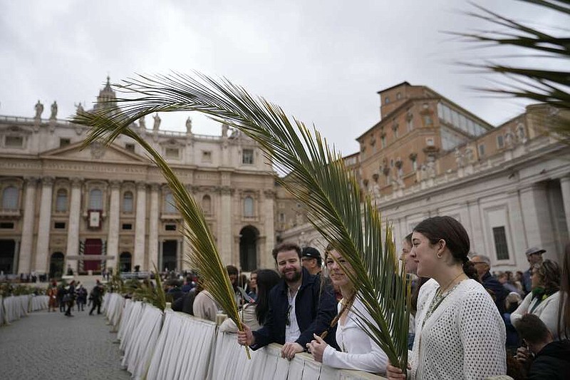 Faithful hold palm branches prior to the start of the Palm Sunday mass in St. Peter's Square at the Vatican, Sunday, March 24, 2024. (AP Photo/Alessandra Tarantino)