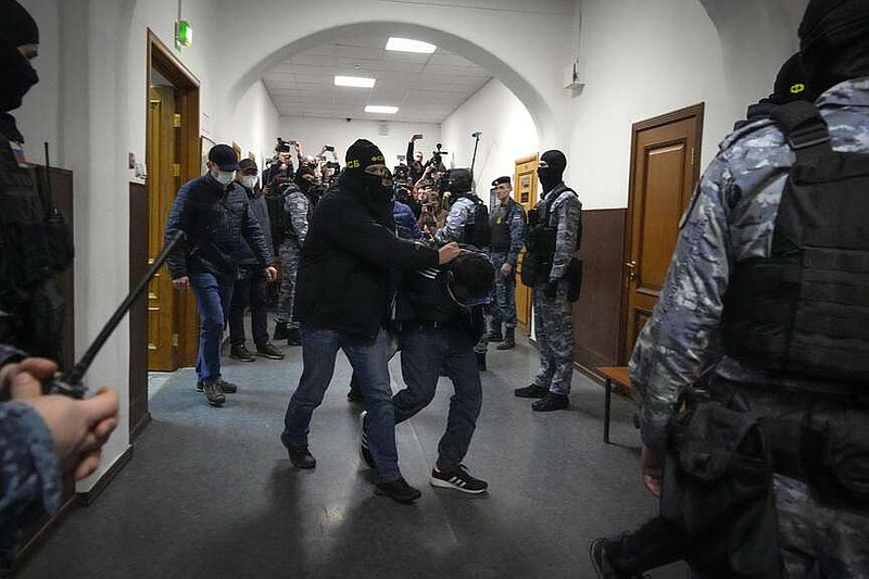 A suspect in the Crocus City Hall shooting on Friday is escorted by police officers in the Basmanny District Court, in Moscow, Russia, Sunday, March 24, 2024. (AP Photo/Alexander Zemlianichenko)