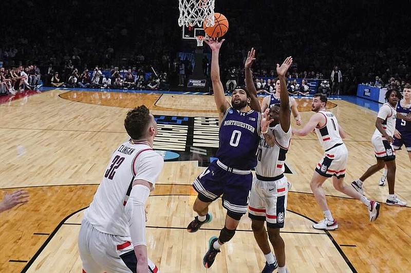 Northwestern's Boo Buie (0) drives past UConn's Hassan Diarra (10) during the first half of a second-round college basketball game in the NCAA Tournament Sunday, March 24, 2024, in New York. (AP Photo/Frank Franklin II)