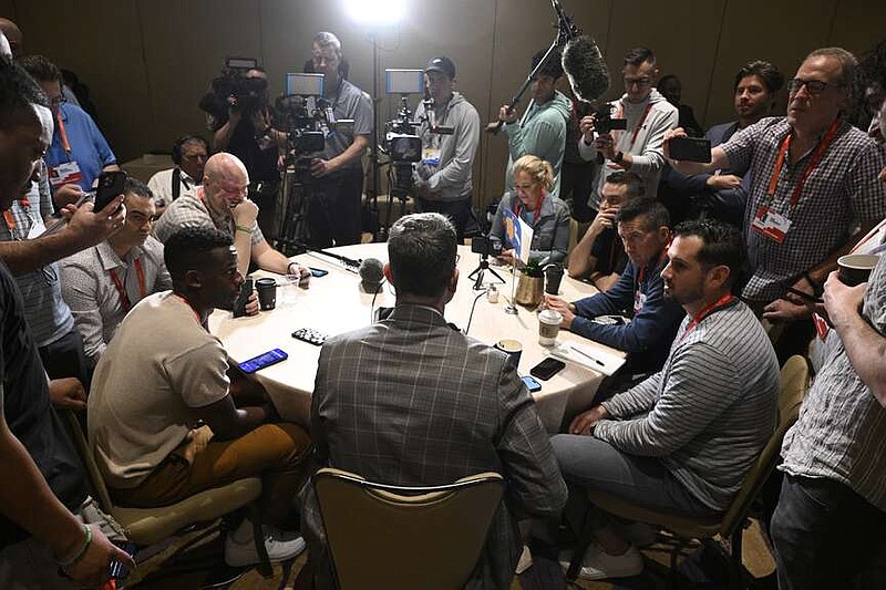 Los Angeles Chargers head coach Jim Harbaugh, center, back to camera, talks with reporters during an AFC coaches availability at the NFL owners meetings, Monday, in Orlando, Fla. (AP Photo/Phelan M. Ebenhack)