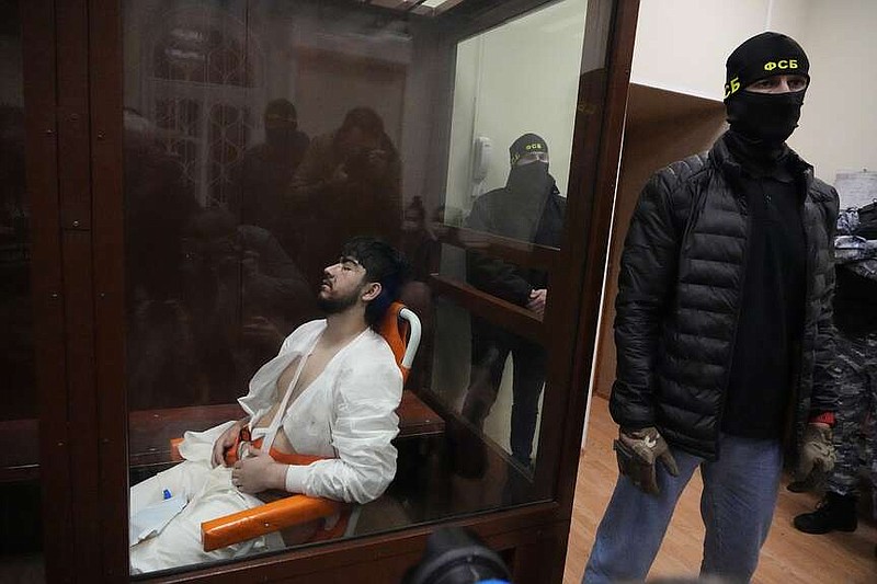 Mukhammadsobir Faizov, a suspect in Friday's shooting at the Crocus City Hall, sits in a glass cage in the Basmanny District Court in Moscow, Russia, Sunday, March 24, 2024. (AP Photo/Alexander Zemlianichenko)