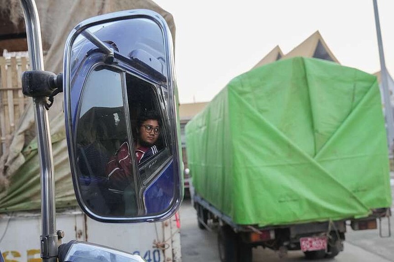 A Myanmar's truck driver is reflected on a mirror as his truck carrying aid leaves at a customs checkpoint near the border with Myanmar, in Mae Sot, Tak province Thailand Monday, March 25, 2024. Thailand delivered its first batch of humanitarian aid to war-torn Myanmar sending ten trucks over the border from the northern province of Tak in what they hope will be a continuing effort to ease the plight of millions of people displaced by fighting. (AP Photo/Sakchai Lalit)