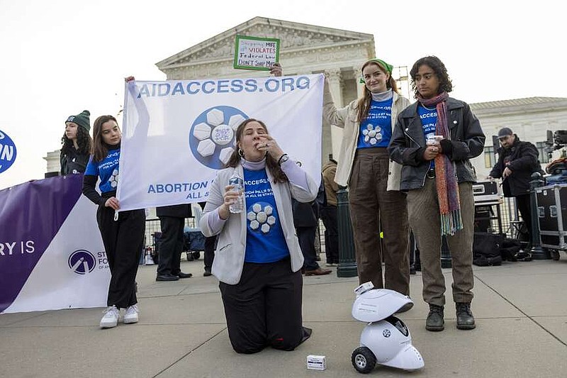 Mira Michels of Aid Access, takes a mifepristone pill in protest as demonstrators from both anti-abortion and abortion rights groups rally outside the Supreme Court in Washington, Tuesday, March 26, 2024. The Supreme Court is hearing arguments in its first abortion case since conservative justices overturned the constitutional right to an abortion two years ago. At stake in Tuesday's arguments is the ease of access to a medication used last year in nearly two-thirds of U.S. abortions. ( (AP Photo/Amanda Andrade-Rhoades)