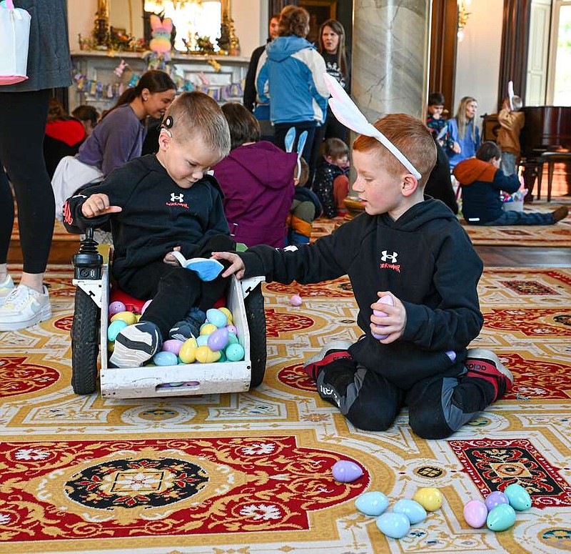 Julie Smith/News Tribune
Hugh Hamill crawls on his hands and knees to retrieve as many eggs as possible during Wednesday's Easter egg hunt at the Governor's Mansion. He was able to secure several for himself and his brother Henry, left, who came to assist.