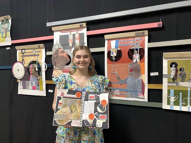 Senior Elliot White stands between two of her art works while holding her sketchbook on Tuesday, March 26, 2024, at Pleasant Grove High School in Texarkana, Texas. White said her pieces were about philosophy and how thoughts changed through time based on popular ideas of the era. (Staff photo by Mallory Wyatt)