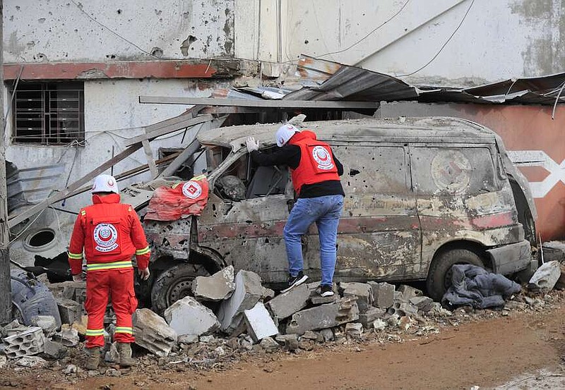 Paramedic workers check a damaged ambulance that parked outside of a paramedic center that was destroyed by an Israeli airstrike early Wednesday in Hebbariye village, south Lebanon, Wednesday, March 27, 2024. The Israeli airstrike on a paramedic center linked to a Lebanese Sunni Muslim group killed several people of its members. The strike was one of the deadliest single attacks since violence erupted along the Lebanon-Israel border more than five months ago. (AP Photo/Mohammed Zaatari)