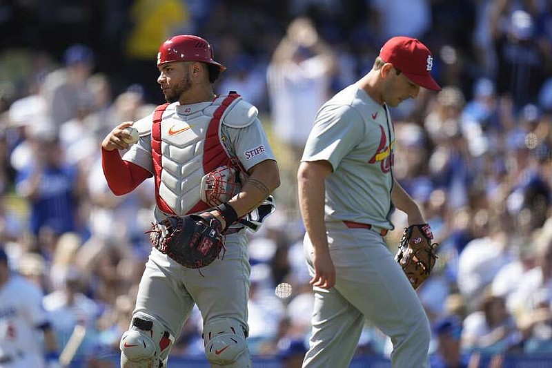 St. Louis Cardinals catcher Willson Contreras, left, and relief pitcher Andre Pallante walk to their positions after giving up an RBI single against Los Angeles Dodgers' James Outman during the sixth inning of a baseball game Thursday, March 28, 2024, in Los Angeles. (AP Photo/Jae C. Hong)