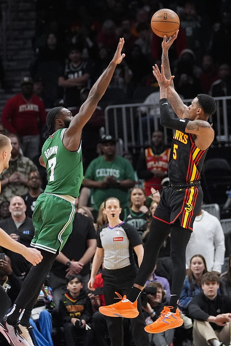Atlanta Hawks guard Dejounte Murray (5) shoots as Boston Celtics guard Jaylen Brown (7) defends during overtime in an NBA basketball game Thursday, March 28, 2024, in Atlanta. (AP Photo/John Bazemore)