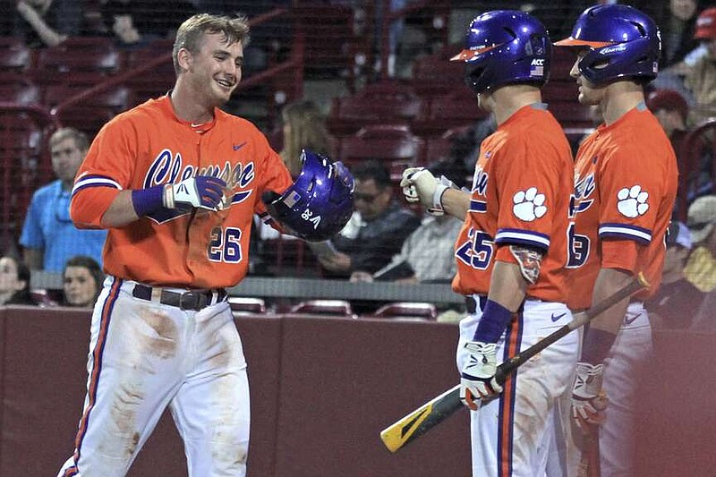 FILE - Clemson's Reed Rohlman, left, returns to the dugout after scoring during an NCAA college baseball game against South Carolina at Carolina Stadium in Columbia, S.C., Monday, March 2, 2015. Reed Rohlman, a former Clemson all-Atlantic Coast Conference outfielder who was drafted in the 35th round by Kansas City and played three years in the Royals organization, has died in Florida, his former school said Friday, March 29, 2024. He was 29. The school said he died Wednesday.(Mark Crammer/The Independent-Mail via AP, File)