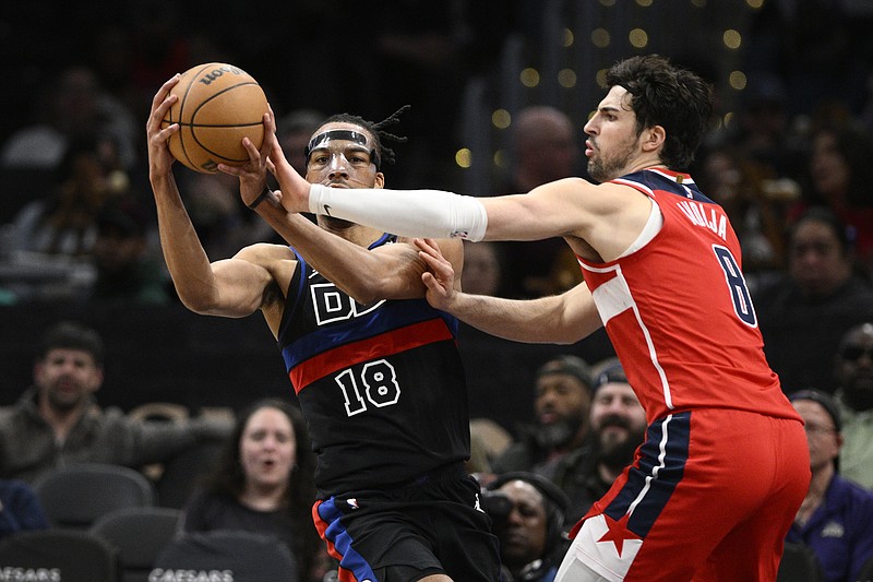 Washington Wizards forward Deni Avdija (8) reaches for the ball as Detroit Pistons forward Tosan Evbuomwan (18) tries to control it during the second half of an NBA basketball game Friday, March 29, 2024, in Washington. (AP Photo/Nick Wass)