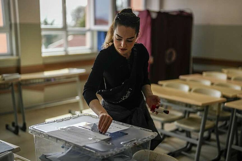 A woman votes at a polling station in Istanbul, Turkey, Sunday, March 31, 2024. Turkey is holding local elections on Sunday that will decide who gets to control Istanbul and other key cities. (AP Photo/Khalil Hamra)
