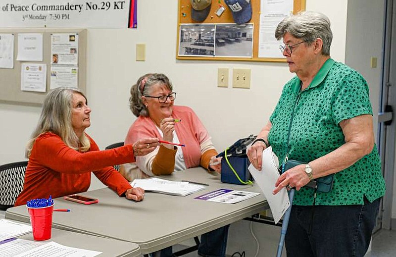 Julie Smith/News Tribune photo: 
Diana Trigg, at right,  is handed an ink pen by Kathy Peerson, after being checked in by Jeannie Brandstetter, middle, Tuesday, April 2, 2024, at Ward 3, Precinct 3 voting at Masonic Lodge on  Masonic Court. Tuesday was a municipal election day in Jefferson City.
