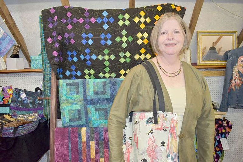 Rachel Dickerson/The Weekly Vista
Lenora Babb holds a Japanese-inspired bag that she made. Behind her are a few quilts that she sewed. Her work is on display at the Wishing Spring Gallery on McNelly Road.