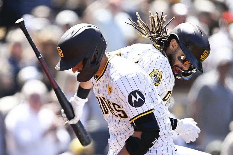 San Diego Padres' Kyle Higashioka (20), left, is congratulated by Fernando Tatis Jr. (23) after hitting a solo home run during the fourth inning of a baseball game against the St. Louis Cardinals, Wednesday, April 3, 2024, in San Diego. (AP Photo/Denis Poroy)