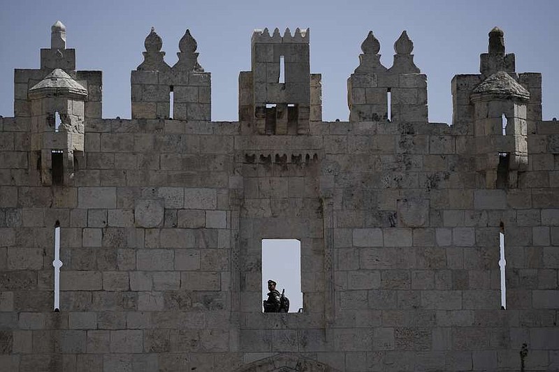 An Israeli Border Police officer stands guard from the Damascus Gate to the Old City of Jerusalem as Muslim worshippers leave the Al-Aqsa Mosque compound after the last Friday prayers of the holy month of Ramadan, Friday, April 5, 2024. (AP Photo/Leo Correa)