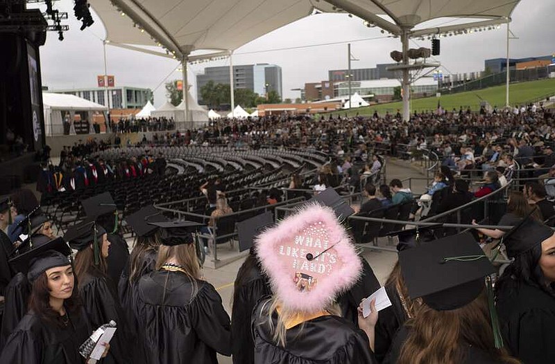 Northwest Arkansas Community College graduating students line up to take their seats, Tuesday, May 16, 2023 at the Walmart Amp in Rogers. (NWA Democrat-Gazette/Charlie Kaijo)