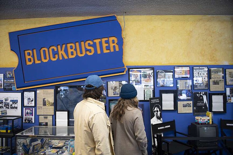 Ben and Shannon Kapp, who were visiting from Olympia, Wash., admire the memorabilia at the last Blockbuster. “A lot of those memories are just walking around the aisles,” said Shannon. MUST CREDIT: Isaac Wasserman for The Washington Post