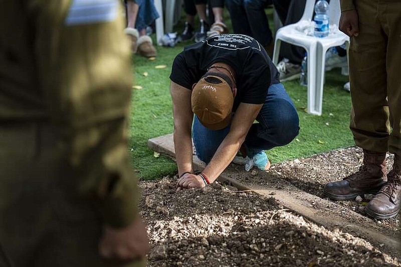 Avraham Harush, father of Israeli solider Sergeant Reef Harush, mourns over his grave in Ramat David, Israel, Sunday, April 7, 2024. Harush, 20, was killed during Israel's ground operation in the Gaza Strip, where the Israeli army has been battling Palestinian militants in the war ignited by Hamas' Oct. 7 attack into Israel. (AP Photo/Ariel Schalit)