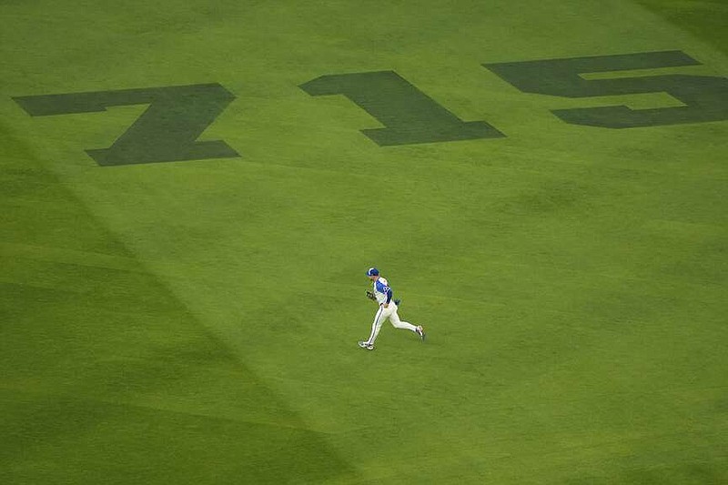 Atlanta Braves outfielder Jarred Kelenic runs on the outfield painted with 715 to mark the 50th anniversary of Hank Aaron breaking Babe Ruth's home run record before a baseball game against the New York Mets Monday, April 8, 2024, in Atlanta. (AP Photo/John Bazemore)